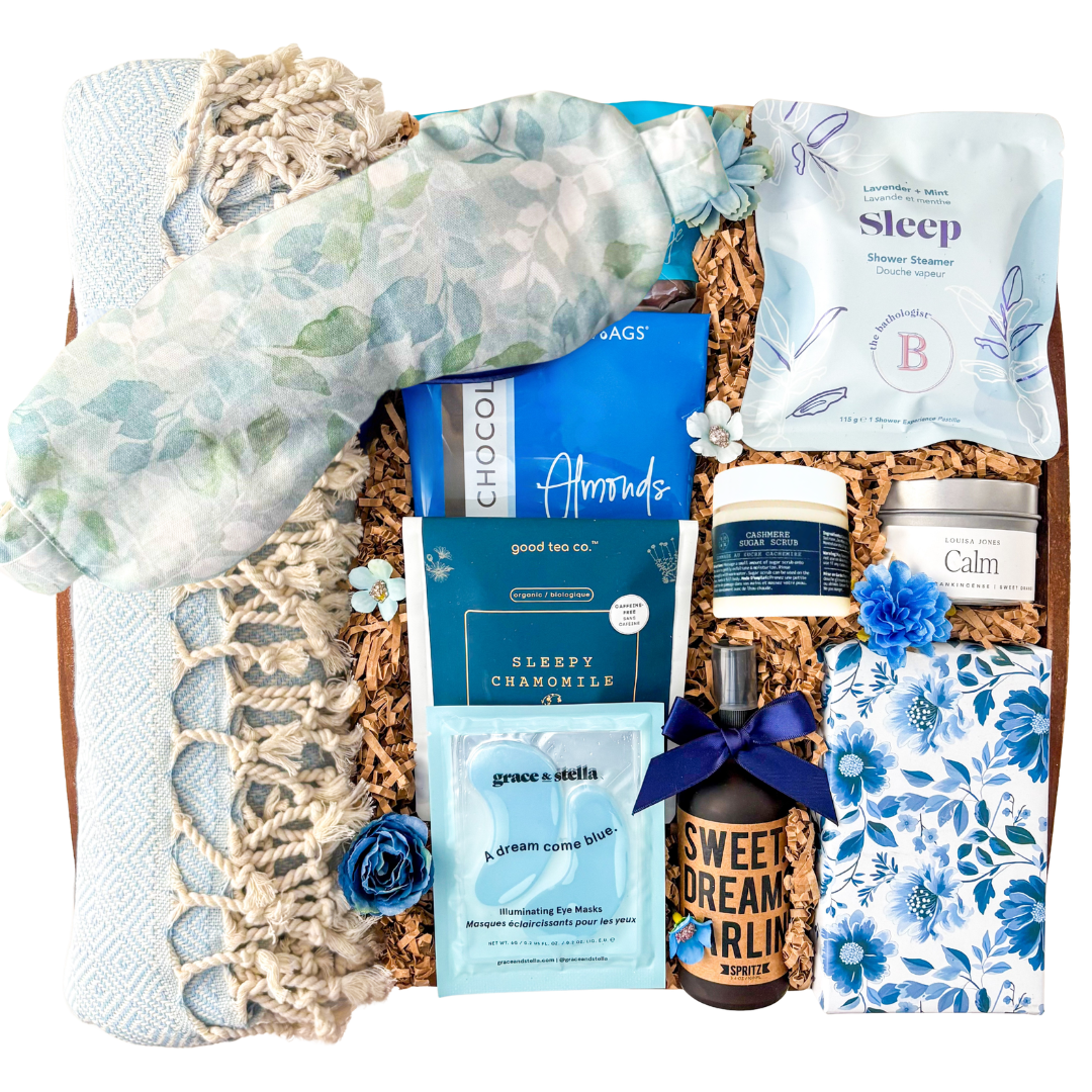 Blue and neutral Sweet Dreams spa gift box featuring Turkish towel, sleep mask, calming self-care products, tea, chocolates, eye masks, and cozy relaxation items in a keepsake wood tray curated by Black Bow Gift Co.