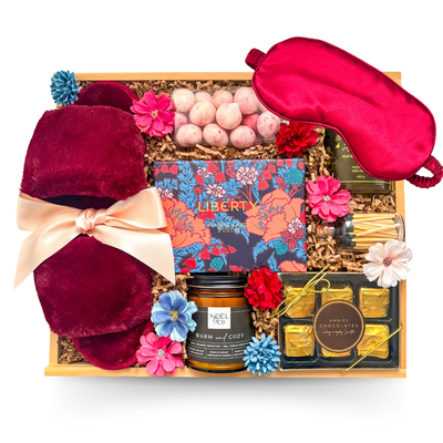 Sweet Escape feminine relaxation gift featuring cozy comforts, chocolates, candle and playing cards in a wooden tray.