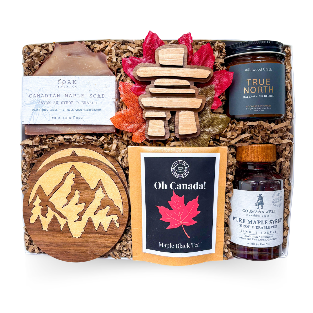 Luxury Canadian gift box featuring pure Canadian maple syrup, maple black tea, handcrafted maple soap, True North soy candle, artisan wood coasters, Canadian inukshuk décor, and premium maple-inspired gifts.