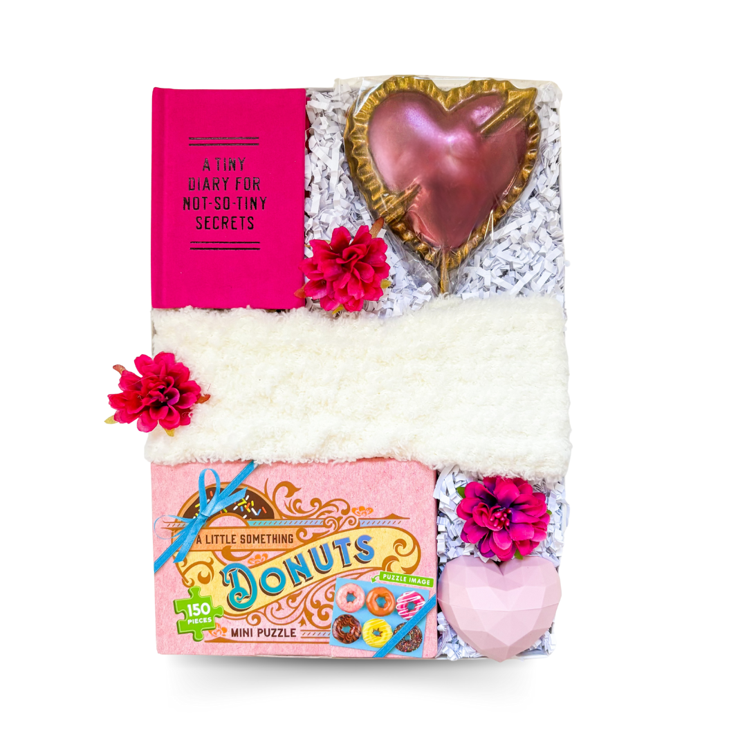 Luxury playful pink gift box with cozy accents and sweet treats
