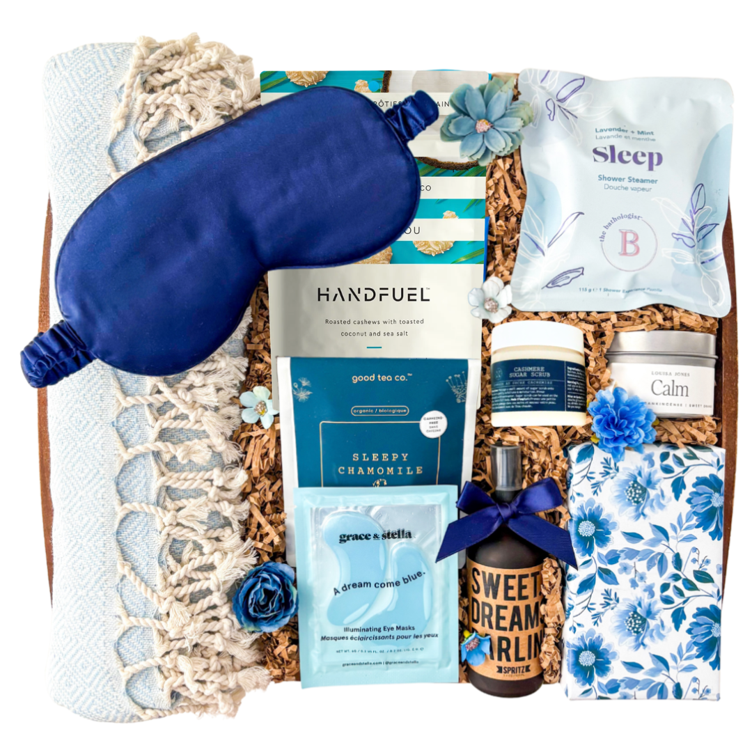 Blue and neutral Sweet Dreams spa gift box featuring Turkish towel, sleep mask, calming self-care products, tea, chocolates, eye masks, and cozy relaxation items in a keepsake wood tray curated by Black Bow Gift Co.