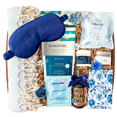 Blue and neutral Sweet Dreams spa gift box featuring Turkish towel, sleep mask, calming self-care products, tea, chocolates, eye masks, and cozy relaxation items in a keepsake wood tray curated by Black Bow Gift Co.
