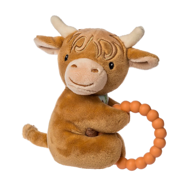 Plush toy cow with a teething ring on a white background