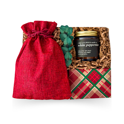 The Holiday Pause Christmas gift box with hot chocolate, caramel popcorn, shortbread cookies, peppermint candle and festive burgundy pouch.