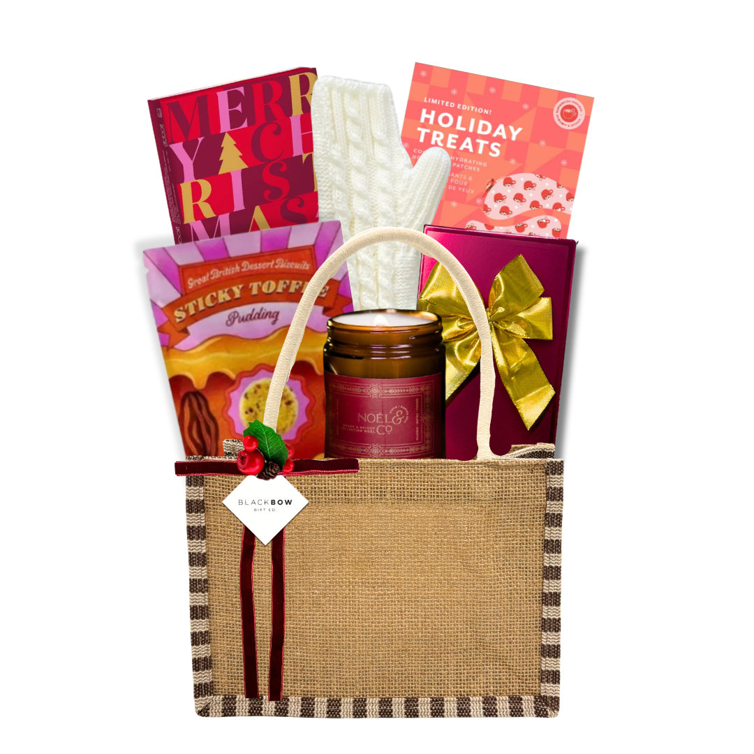 The Winter Retreat luxury gift featuring ivory cable-knit gloves, gourmet chocolates, sweet treats and a candle presented in a reusable natural linen tote.