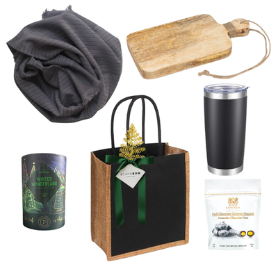 The Winter Standard holiday gift featuring a black insulated tumbler, charcoal hand towel, rustic wooden serving board, gourmet chocolate almonds and seasonal tea.