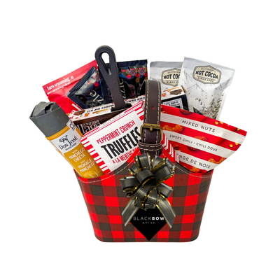 The Great Indoors gourmet gift basket featuring hot chocolate, peppermint truffles, gourmet nuts and savoury snacks in a red and black buffalo plaid keepsake basket.
