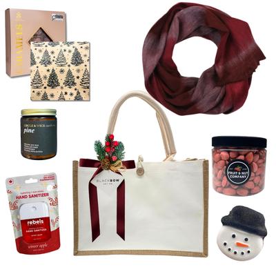 The Holiday Embrace Christmas gift featuring a burgundy scarf, pine-scented candle, gourmet chocolates, festive nuts, holiday treats and an elegant reusable tote.