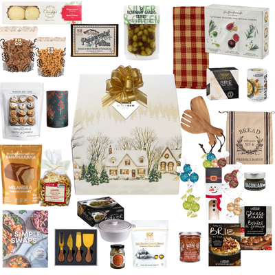 The Holiday Host luxury Christmas gift in elegant winter village keepsake packaging, featuring snowy cottages, festive trees, a gold bow and Black Bow Gift Co. tag.