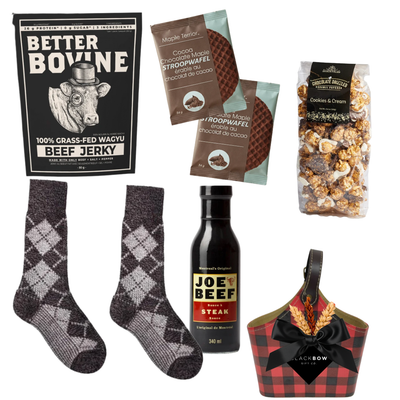 The Winter Explorer gift basket featuring a red and black buffalo plaid keepsake caddy filled with gourmet snacks, winter accessories and cozy wool gloves with an optional sock selection.