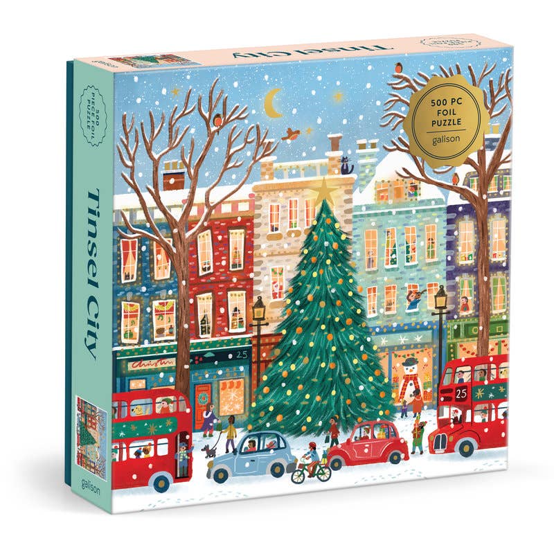 Tinsel City 500-piece Christmas puzzle featuring a festive winter city street with decorated Christmas trees and holiday details.