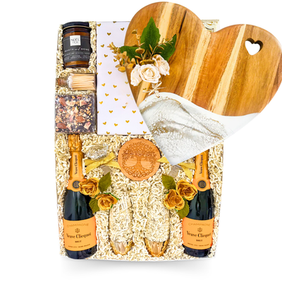 Luxury champagne gift box featuring Veuve Clicquot, champagne flutes, gourmet treats, romantic accents, and XL keepsake presentation by Black Bow Gift Co.