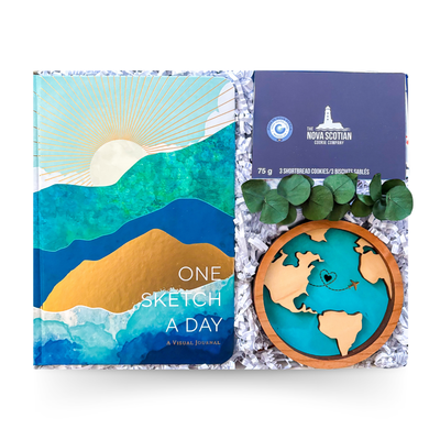 Travel-themed gift box featuring a journal, travel challenge cards, keepsake ornament, and gourmet treats presented by Black Bow Gift Co.
