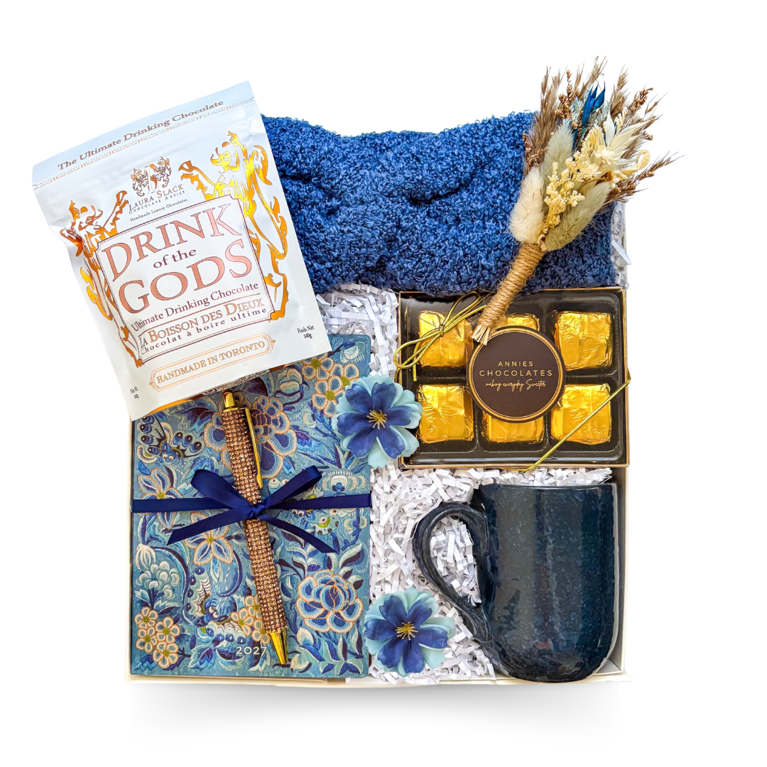 Warm Thoughts cozy gift box with soft blue headband, journal and pen, textured mug, chocolates and a choice of gourmet hot chocolate or tea, thoughtfully packaged by Black Bow Gift Co.

