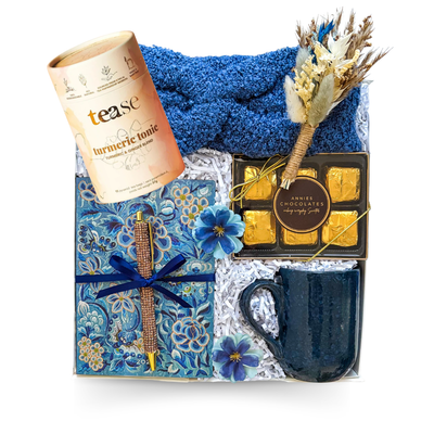 Warm Thoughts cozy gift box with soft blue headband, journal and pen, textured mug, chocolates and a choice of gourmet hot chocolate or tea, thoughtfully packaged by Black Bow Gift Co.