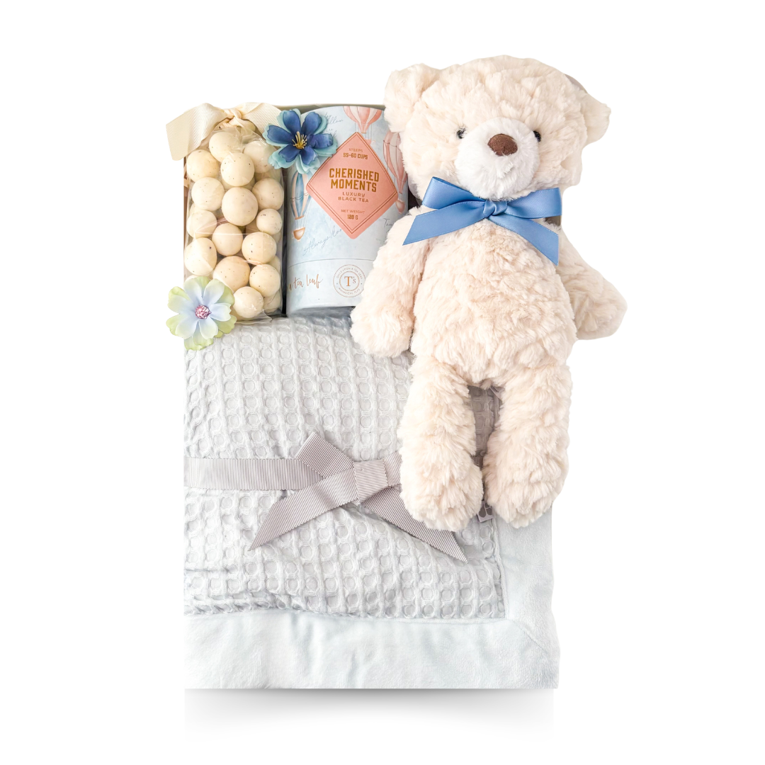 Welcome Baby Boy gift basket with a soft blue baby blanket, cuddly teddy bear, luxury tea and sweet treats, thoughtfully presented by Black Bow Gift Co.