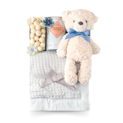 Welcome Baby Boy gift basket with a soft blue baby blanket, cuddly teddy bear, luxury tea and sweet treats, thoughtfully presented by Black Bow Gift Co.