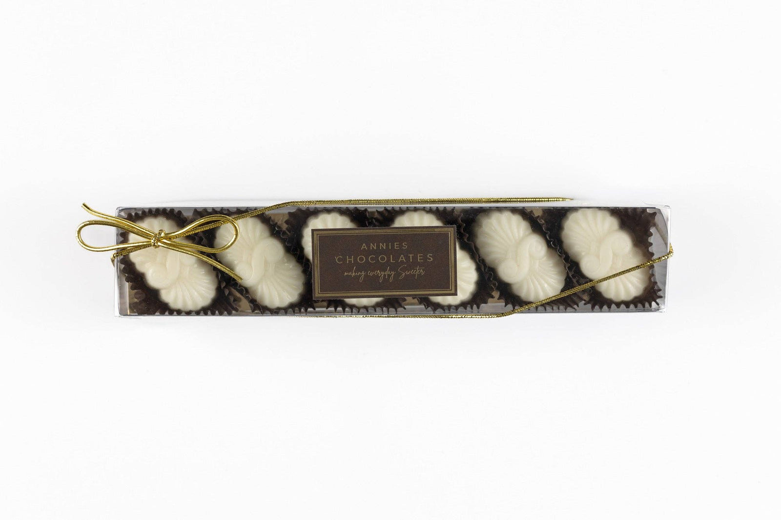 Annie’s Chocolates raspberry cheesecake filling covered in white chocolate presented in a clear lid box.
