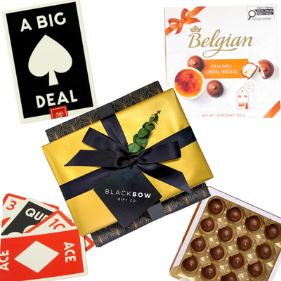 Gift featuring a card game, premium Belgian chocolates, and decorative presentation with ribbon and gift accents by Black Bow Gift Co.