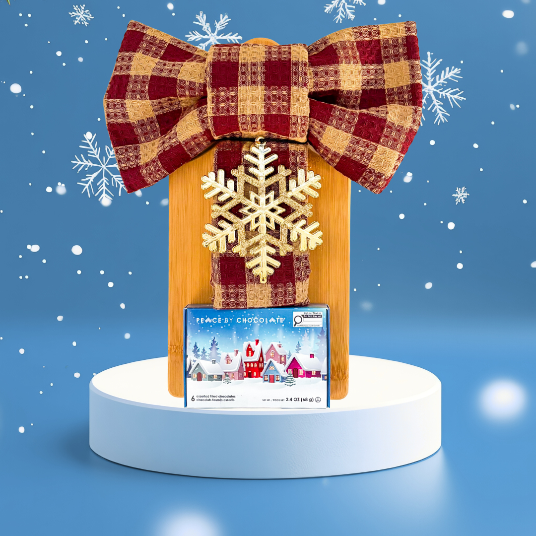 Winter Board holiday gift with wooden board, bow-tied tea towels, snowflake ornament, and festive chocolates.