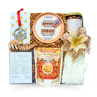 Winter Glow Box with white knit gloves, white and gold holiday candle, festive ornament, winter treats, and gold-accented packaging