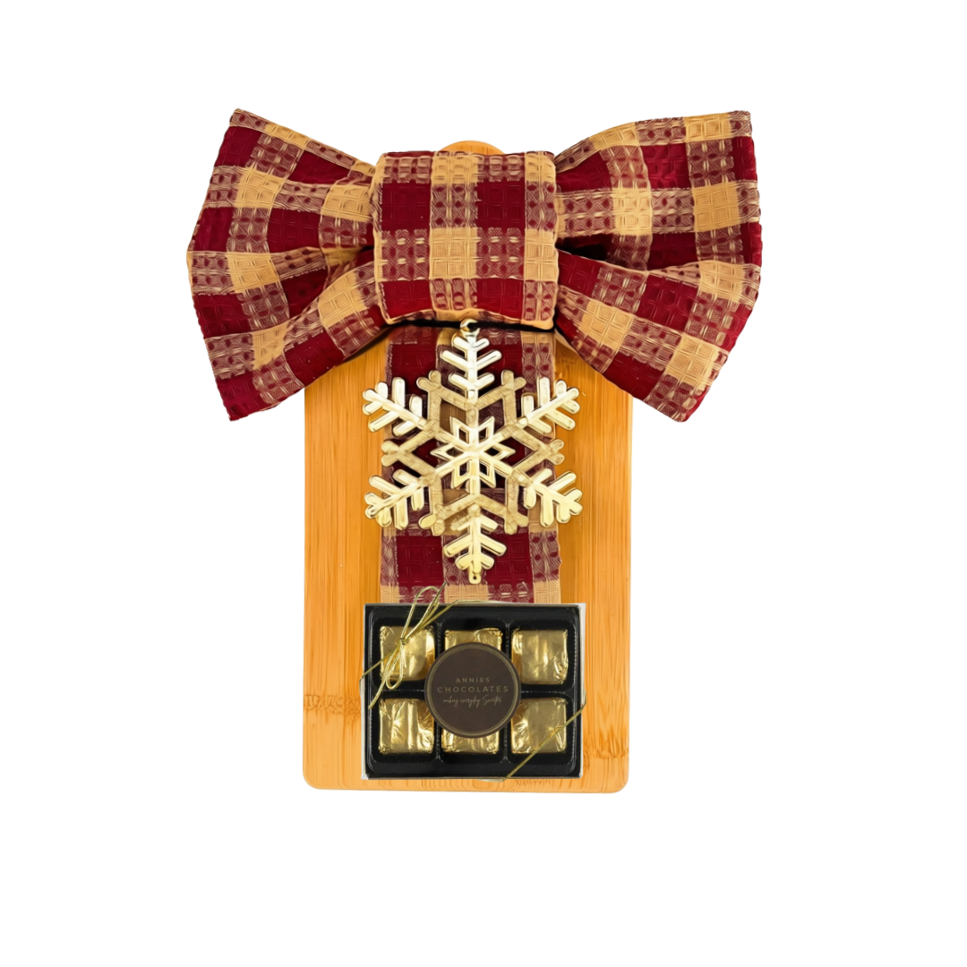Winter Board holiday gift with wooden board, bow-tied tea towels, snowflake ornament, and festive chocolates.