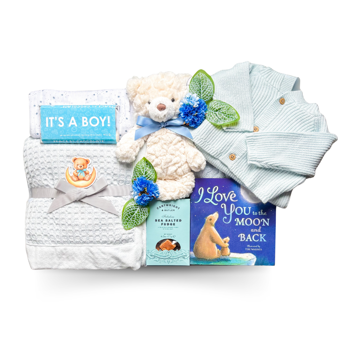 Wrapped in Blue luxury baby boy gift box with baby blanket, blue knit outfit, teddy bear, bedtime book, bath products, eye mask, and cozy newborn essentials in an XL gift box.
