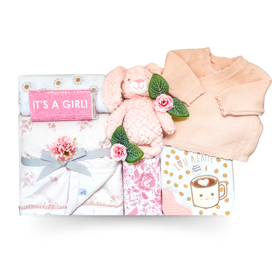 Luxury baby girl gift box with pink knit cardigan, floral baby blanket, plush bunny, baby essentials, treats, and self-care gifts for mom in an XL white gift box.
