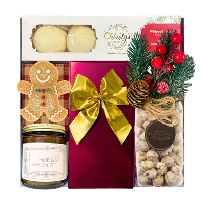 Wrapped in Christmas festive gift box featuring gourmet holiday treats, Belgian chocolates, a seasonal candle, Christmas greenery and a choice of cozy blanket.