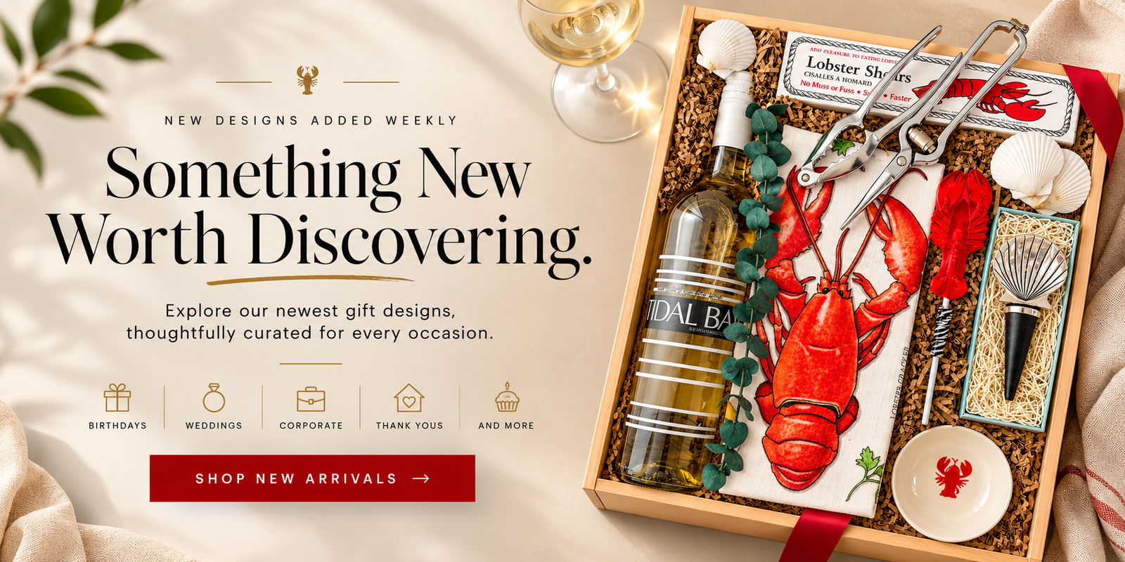 A curated lobster and wine gift set displayed in an open wooden box on a light fabric surface. The set includes a bottle of white wine, a red lobster figurine, silver lobster tools, seashells, a small dish, and a card, arranged next to promotional text reading 'Something New Worth Discovering.