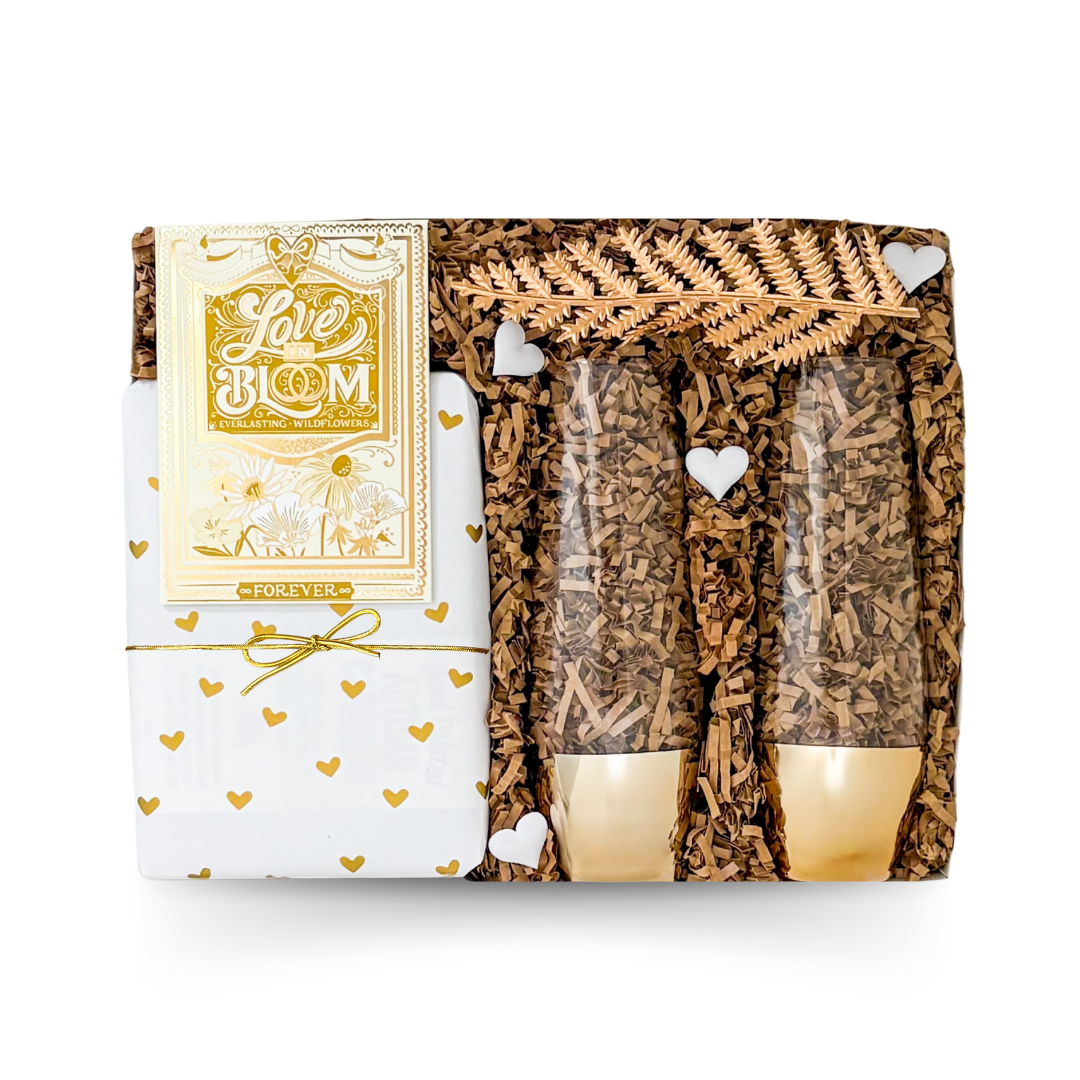Elegant wedding gift box featuring keepsake champagne flutes, wrapped hand painted caramels, and a Love in Bloom seed packet by Black Bow Gift Co.