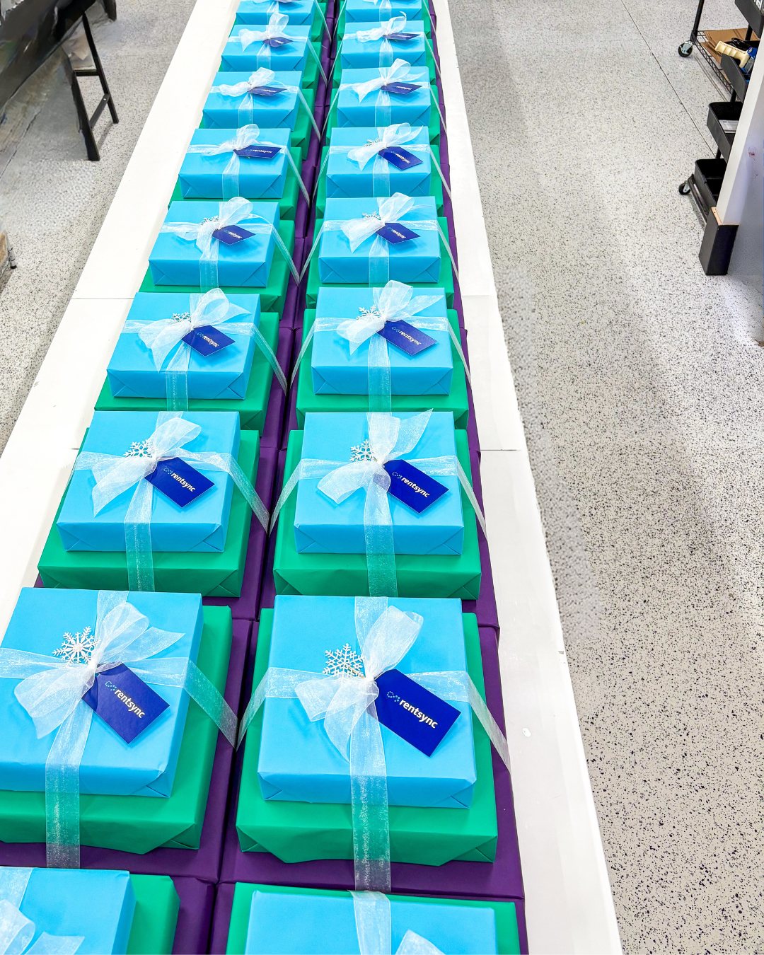 A long studio table lined with matching gift boxes, ready to ship.