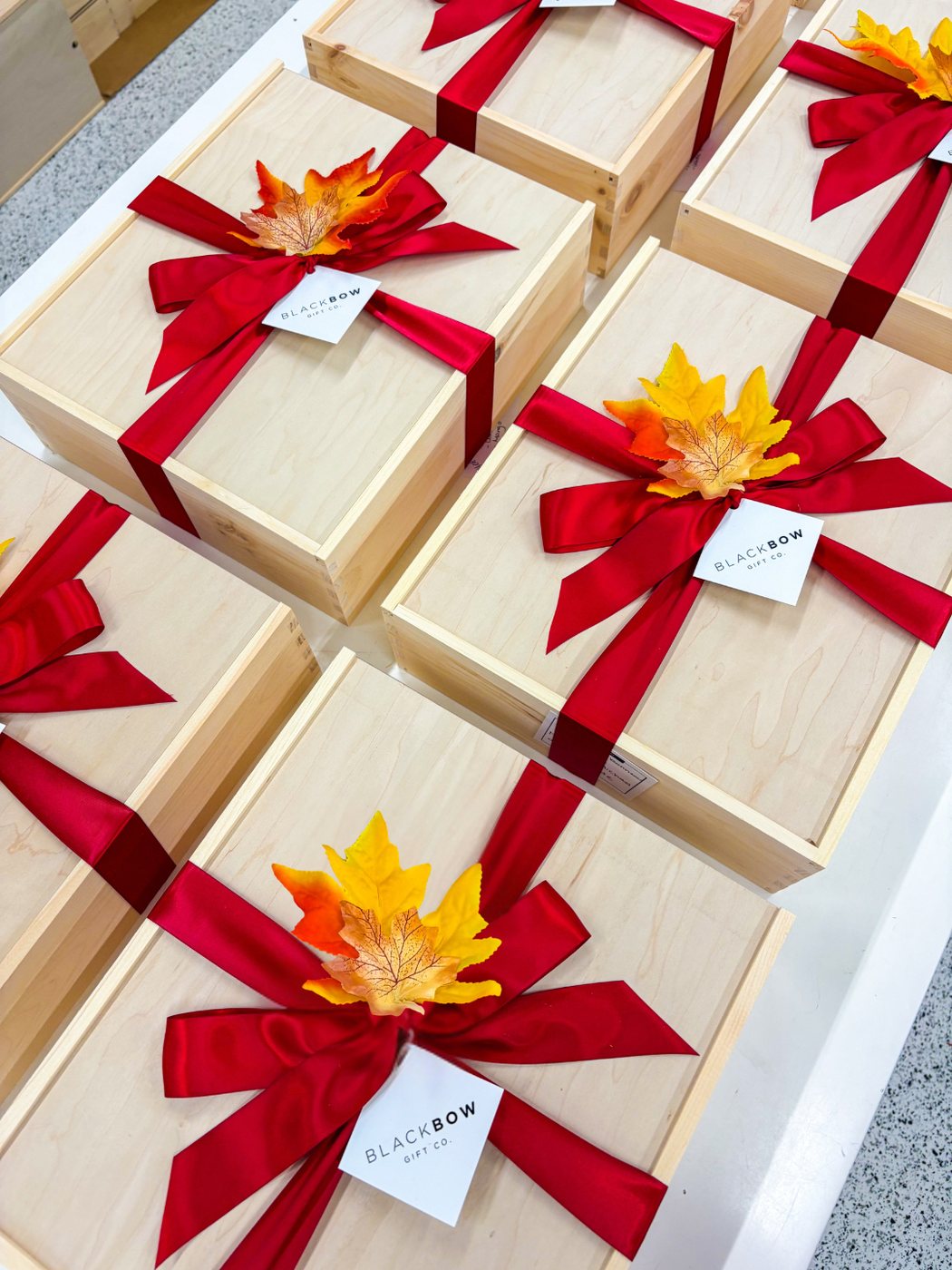 Finished wooden gift boxes tied with red ribbon and tags, ready to give.