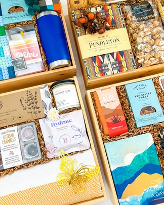 Open gift boxes filled with curated products, candles and snacks.
