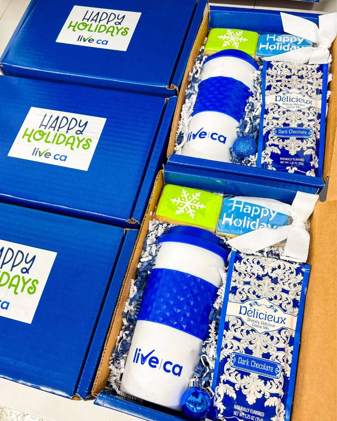 Blue Live CA “Happy Holidays” mailer boxes with branded tumblers.