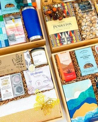 Shelves of pre-designed gift boxes with blankets, candles, snacks and cards.